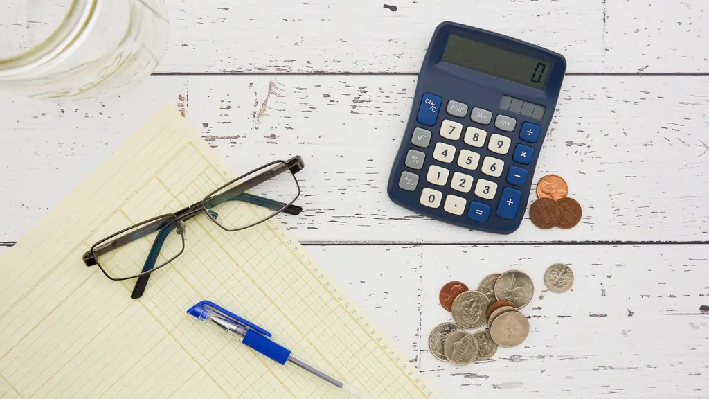 Calculator, glasses and coins on a desk