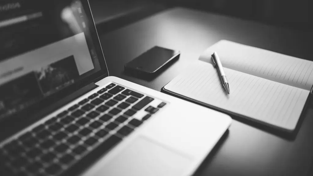 Laptop and notebook on a dark desk
